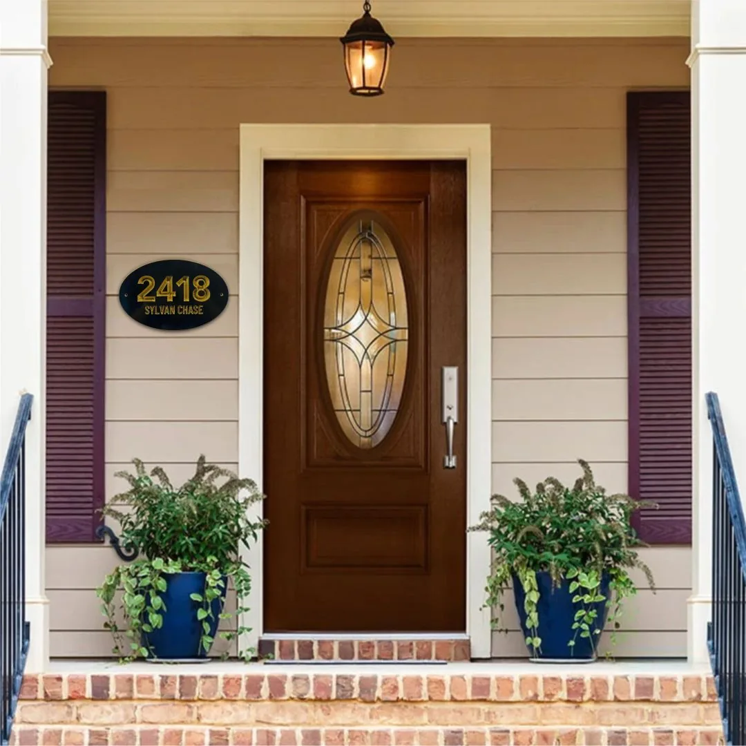 Oval address plaque reading 2418 beside a wood front door with potted plants