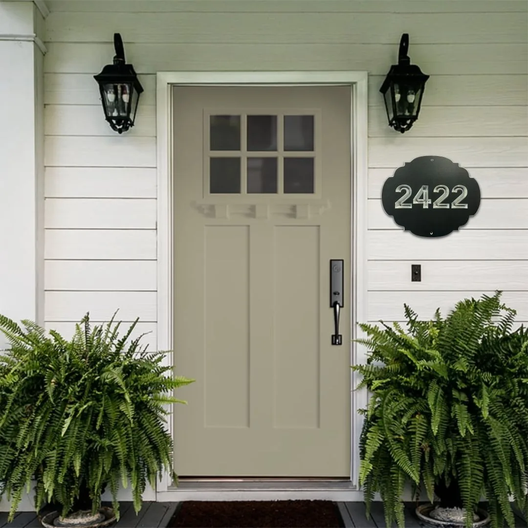 Charcoal shaped address plaque reading 2422 beside a front door between two lanterns