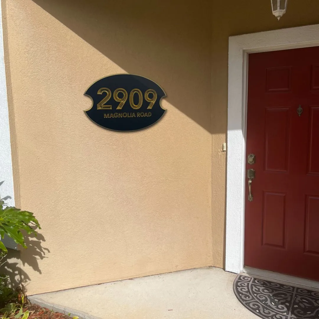 2909 address plaque on a stucco wall by a red door