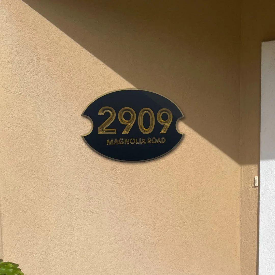 Oval 2909 Magnolia Road address plaque mounted on stucco