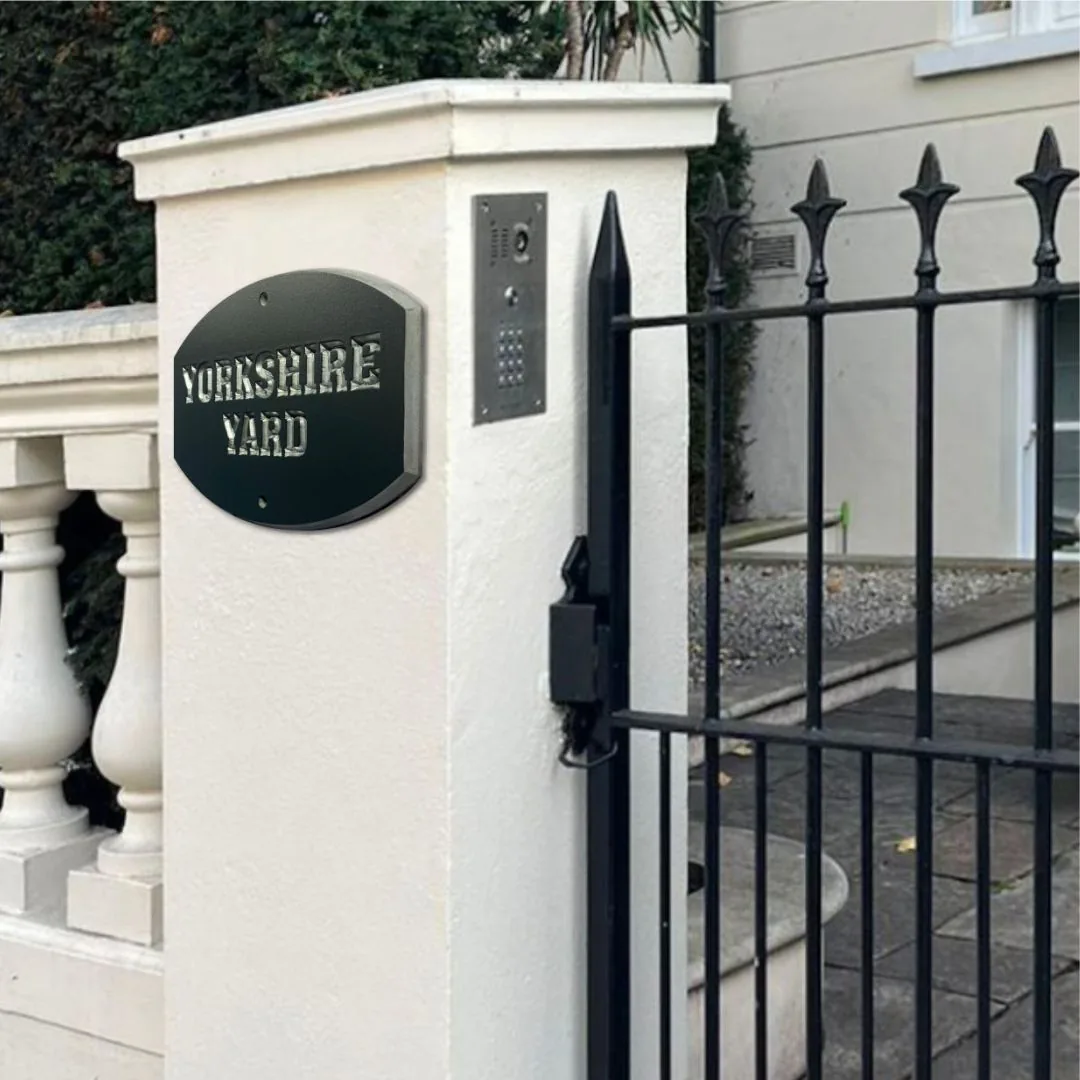 Yorkshire Yard plaque on a pillar beside an iron gate