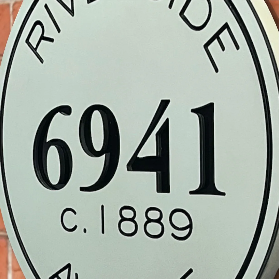 Detail of the raised 6941 numbers and c. 1889 date on the round sign