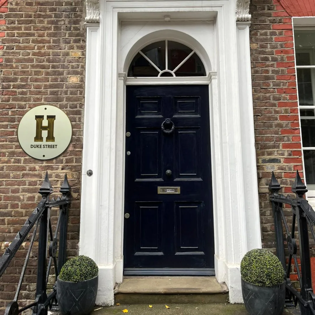 H Duke Street round house plaque beside a navy front door