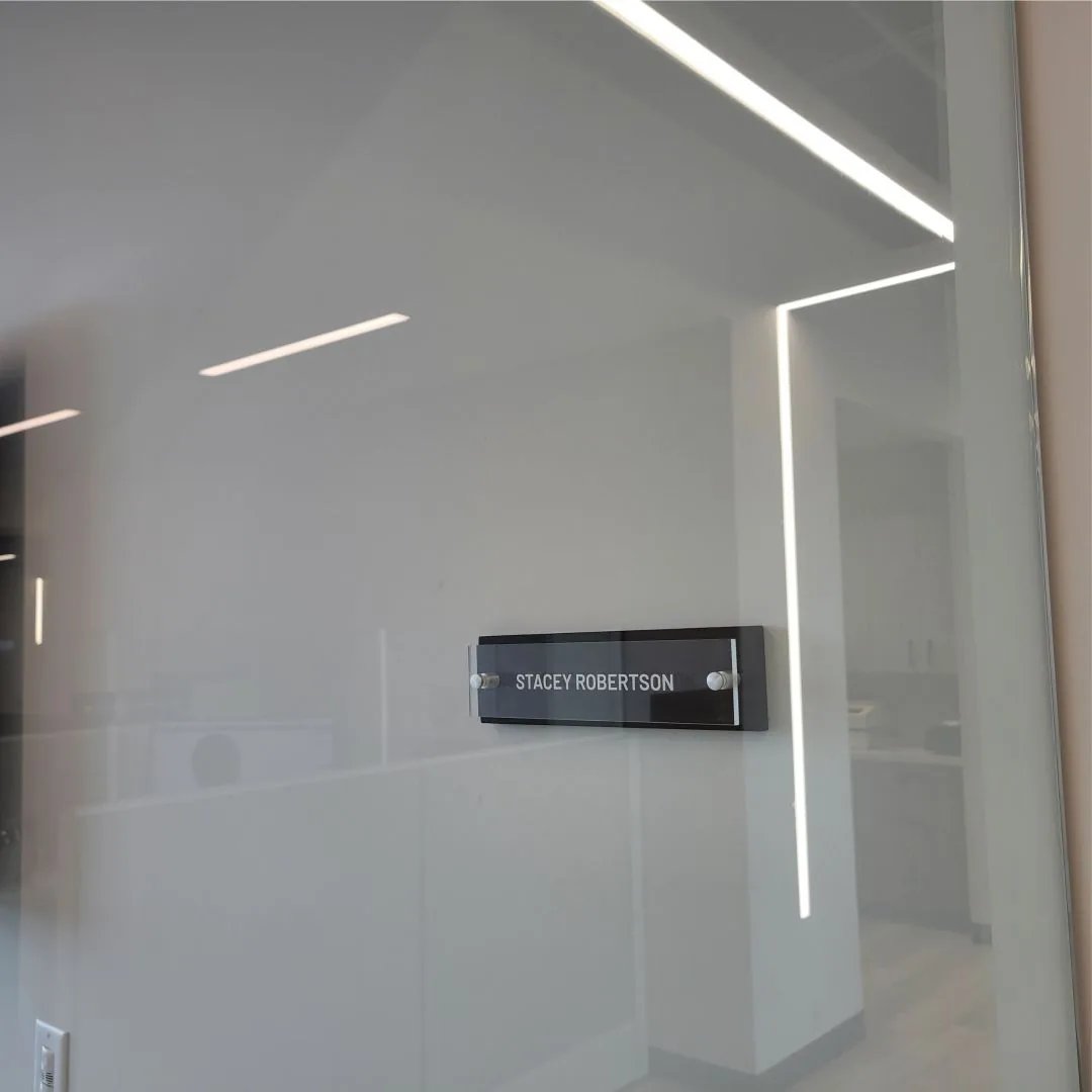 Acrylic name sign on a glass office wall