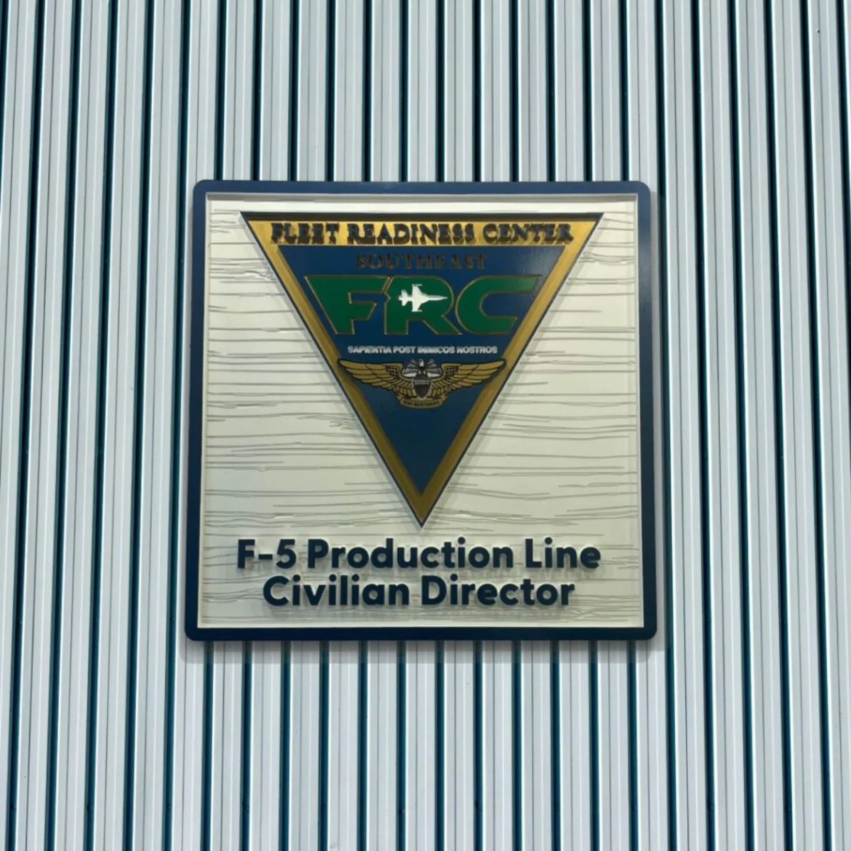 Fleet Readiness Center crest with an F-5 Production Line Civilian Director title on a ribbed wall