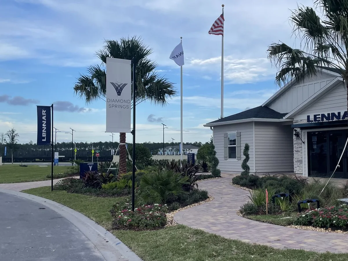 Brand 9 Signs pole banners and flags along the entry walk at the Lennar Diamond Springs welcome center in Florida